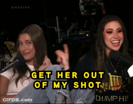 Two Women Are Sitting In Front Of Microphones With The Words Get Her Out Of My Shot On The Bottom GIF