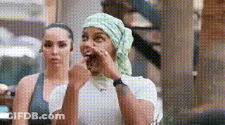 Two Women Are Sitting Next To Each Other And One Of Them Is Wearing A Bandana On Her Head . GIF