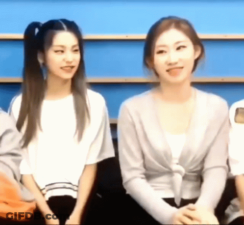 Two Women Are Sitting Next To Each Other In A Room And Smiling . GIF