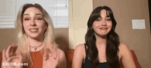 Two Women Are Sitting Next To Each Other On A Couch And Talking To Each Other . GIF