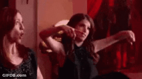 Two Women Are Sitting Next To Each Other On A Couch In A Room . GIF