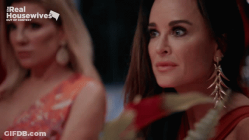 Two Women Are Sitting Next To Each Other With A Real Housewives Logo In The Background GIF