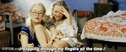 Two Women Are Sitting Next To Each Other With The Words " Slipping Through My Fingers All The Time " Above Them GIF