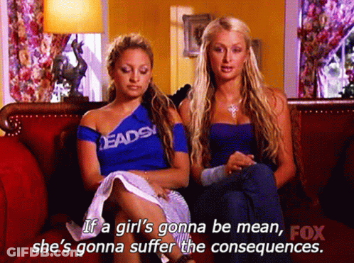 Two Women Are Sitting On A Couch And One Of Them Is Wearing A Shirt That Says " Deads " GIF