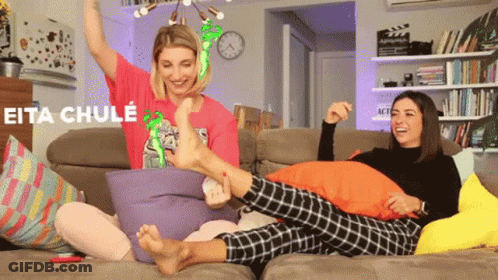 Two Women Are Sitting On A Couch And One Of Them Is Wearing A Shirt That Says Eita Chule On It GIF