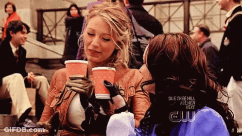 Two Women Are Sitting On A Set Of Stairs Drinking Coffee From Cups . GIF