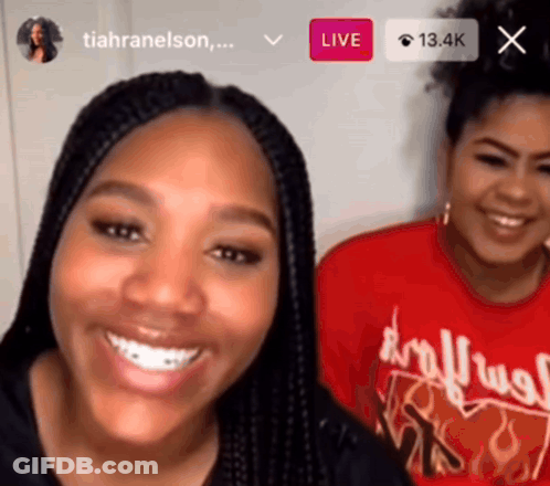 Two Women Are Smiling In Front Of A Screen That Says Live On It GIF