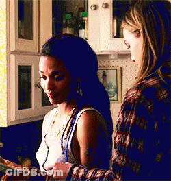 Two Women Are Standing In A Kitchen Looking At A Piece Of Paper . GIF