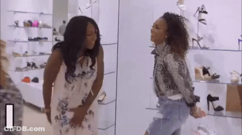 Two Women Are Standing In A Shoe Store Looking At Each Other . GIF