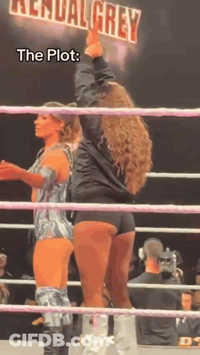 Two Women Are Standing In A Wrestling Ring With A Sign That Says Kendal Grey GIF