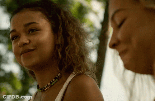 Two Women Are Standing Next To Each Other And One Has A Necklace On GIF