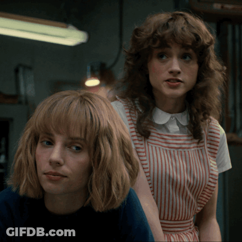 Two Women Are Standing Next To Each Other And One Is Wearing A Striped Dress GIF