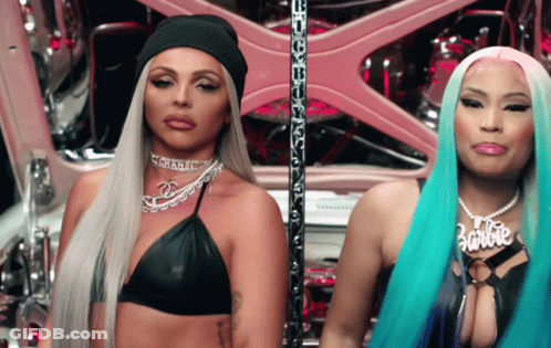 Two Women Are Standing Next To Each Other And One Of Them Has A Necklace That Says Barbie GIF