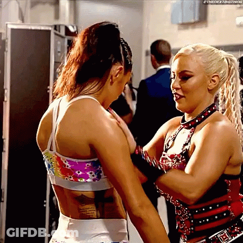 Two Women Are Standing Next To Each Other And One Of Them Has A Tattoo On Her Back . GIF