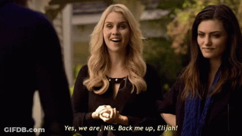 Two Women Are Standing Next To Each Other And One Of Them Is Saying Yes We Are Nik Back Me Up Elijah GIF