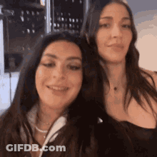 Two Women Are Standing Next To Each Other And Smiling For The Camera . GIF