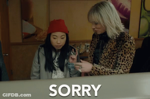 Two Women Are Standing Next To Each Other And The Word Sorry Is On The Counter GIF