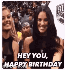 Two Women Are Standing Next To Each Other In A Crowd . GIF
