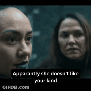 Two Women Are Standing Next To Each Other In A Dark Room . GIF