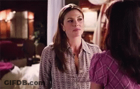 Two Women Are Standing Next To Each Other In A Living Room Talking To Each Other . GIF