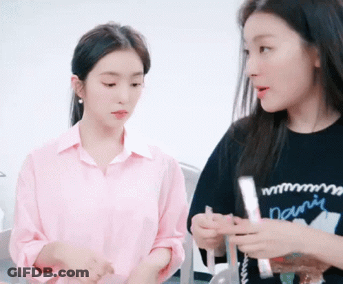 Two Women Are Standing Next To Each Other In A Room . GIF