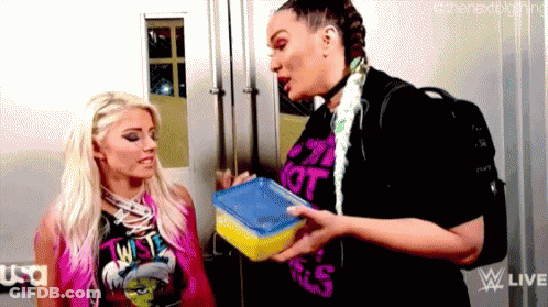 Two Women Are Standing Next To Each Other In A Room And One Is Holding A Lunch Box . GIF