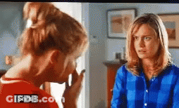 Two Women Are Standing Next To Each Other In A Room And One Of Them Is Wearing A Blue Shirt That Says Sniffs . GIF