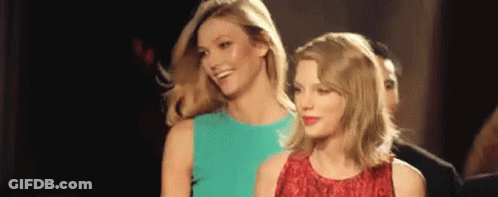 Two Women Are Standing Next To Each Other In A Room And Smiling . GIF