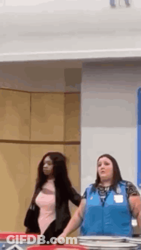 Two Women Are Standing Next To Each Other In A Room In A Store . GIF