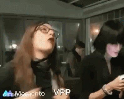 Two Women Are Standing Next To Each Other In A Room . One Of The Women Is Wearing Glasses . GIF