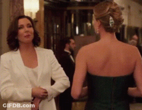 Two Women Are Standing Next To Each Other In A Room Talking To Each Other . GIF