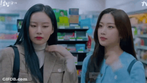 Two Women Are Standing Next To Each Other In A Store And One Of Them Has A Name Tag That Says A135 GIF