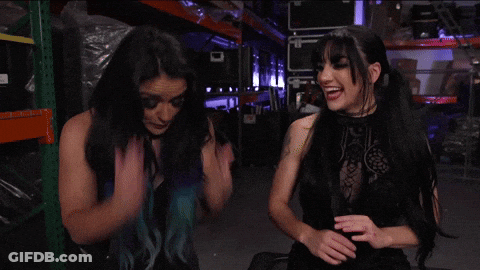 Two Women Are Standing Next To Each Other In A Warehouse And One Of Them Has Blue Hair GIF