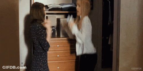 Two Women Are Standing Next To Each Other In Front Of A Dresser In A Room . GIF