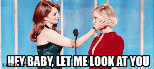 Two Women Are Standing Next To Each Other In Front Of A Microphone And One Of Them Is Touching The Face Of The Other . GIF