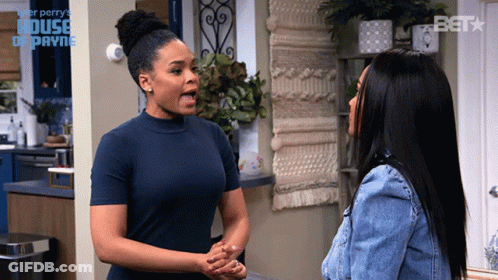 Two Women Are Standing Next To Each Other In Front Of A Sign That Says ' House Of Payne ' On It GIF