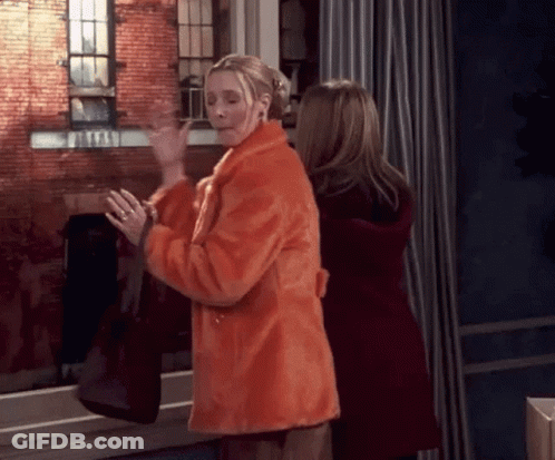 Two Women Are Standing Next To Each Other In Front Of A Window . GIF