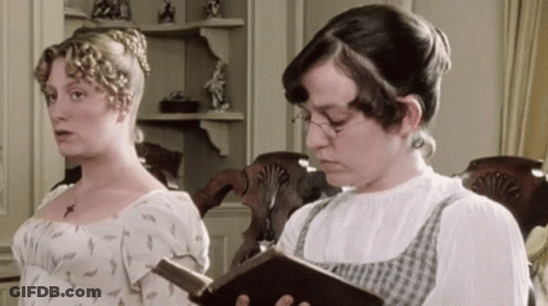 Two Women Are Standing Next To Each Other One Reading A Book GIF