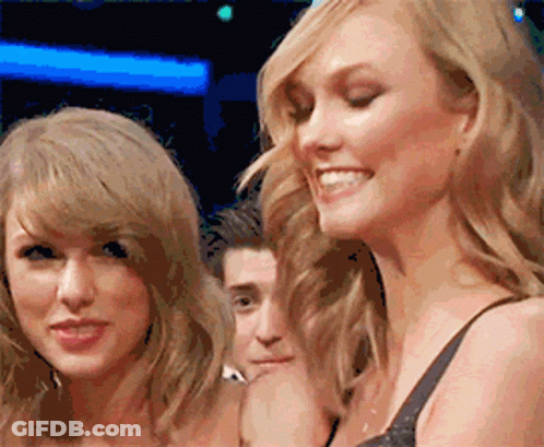 Two Women Are Standing Next To Each Other Smiling And Looking At The Camera GIF