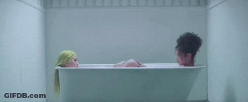 Two Women Are Taking A Bath In A Bathtub . GIF