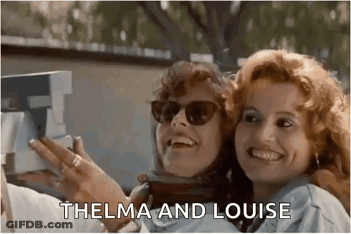 Two Women Are Taking A Picture With A Polaroid Camera And Smiling . GIF