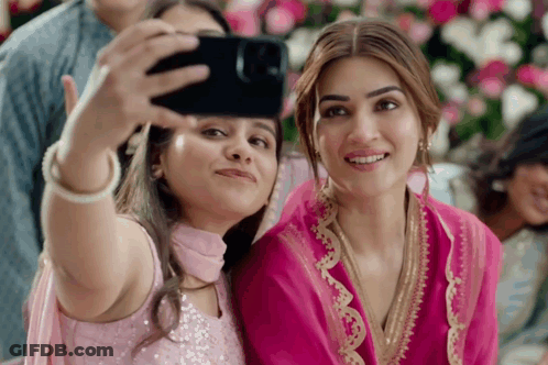 Two Women Are Taking A Selfie With A Phone GIF