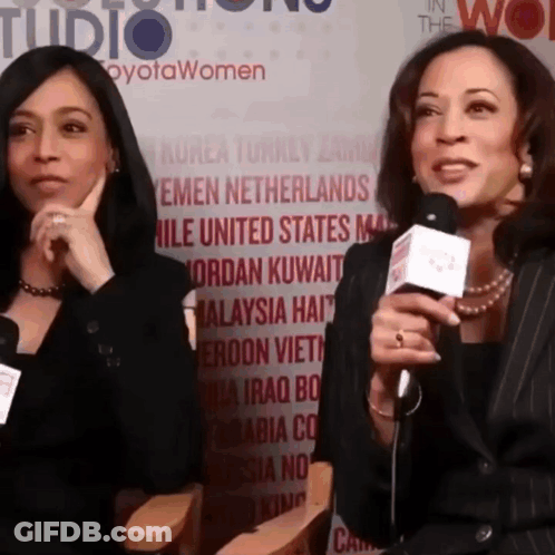 Two Women Are Talking Into Microphones In Front Of A Wall That Says " In The Wo " GIF