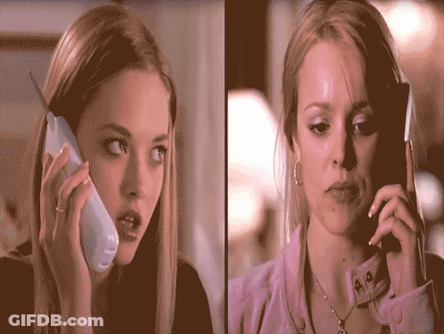 Two Women Are Talking On Their Cell Phones And One Has A Ring On Her Finger GIF