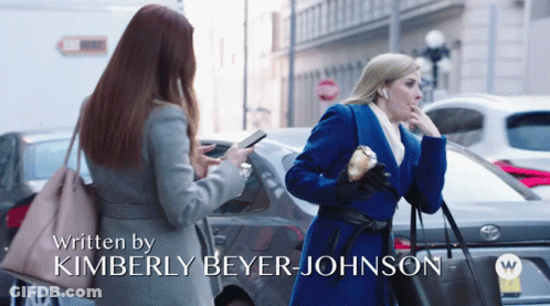 Two Women Are Walking Down A Street With The Words Written By Kimberly Beyer Johnson On The Bottom GIF
