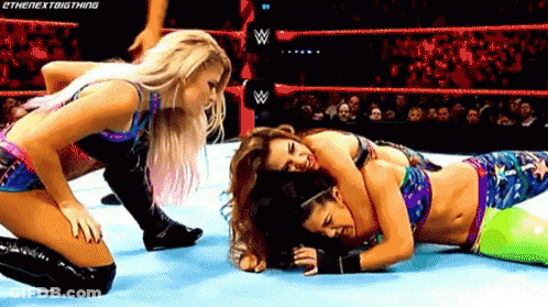Two Women Are Wrestling In A Wrestling Ring And One Of Them Is Laying On The Ground . GIF