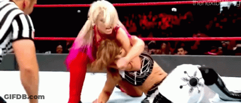 Two Women Are Wrestling In A Wrestling Ring With A Referee Watching . GIF