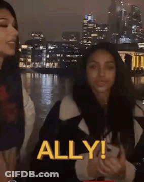 Two Women At Night City One Holding Phone GIF