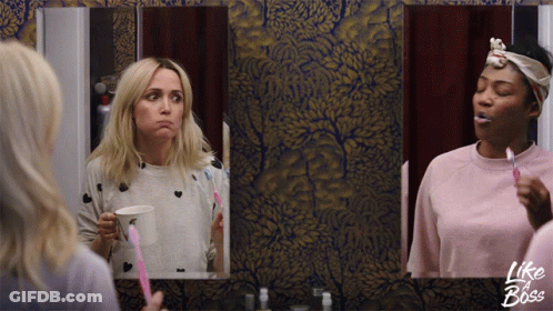 Two Women Brushing Their Teeth In Front Of A Mirror With Like A Boss Written On The Bottom GIF