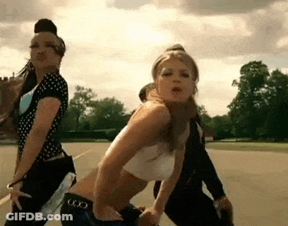 Two Women Dancing In Field With Man Behind GIF